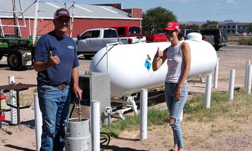 Olsen Grain staff standing in front of propane tanks