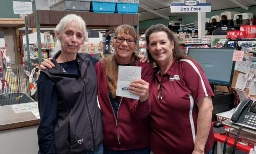 Olsen Grain staff holding a gift card inside of the store